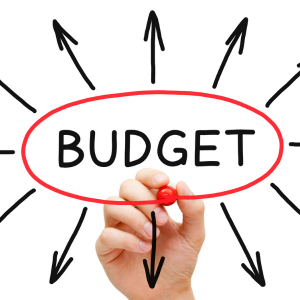 Hand writing budget with arrows