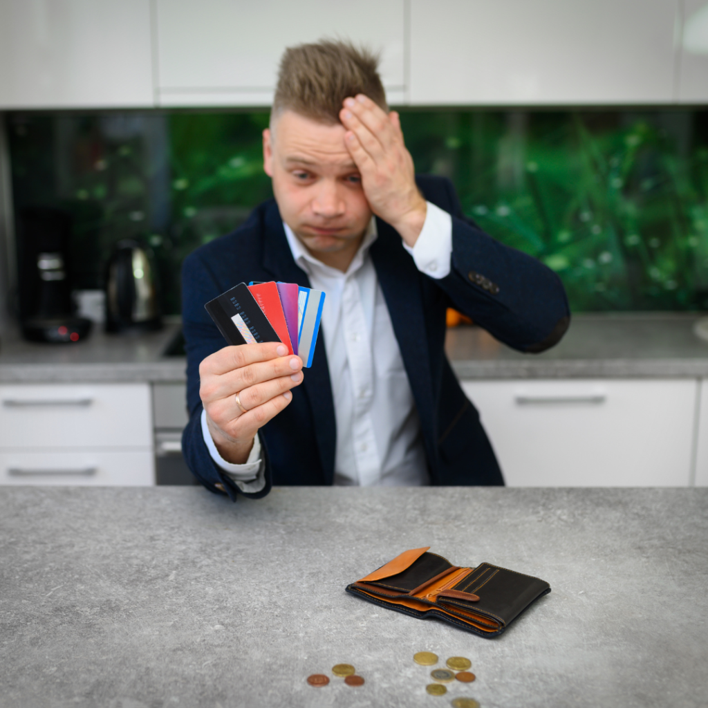 A young man holding a number of credit cards thinking how long to pay off credit card debt