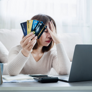 Stressed woman holding credit cards