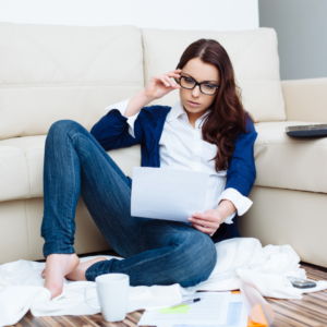 Woman reviewing bills on the floor for a no stress bill system \